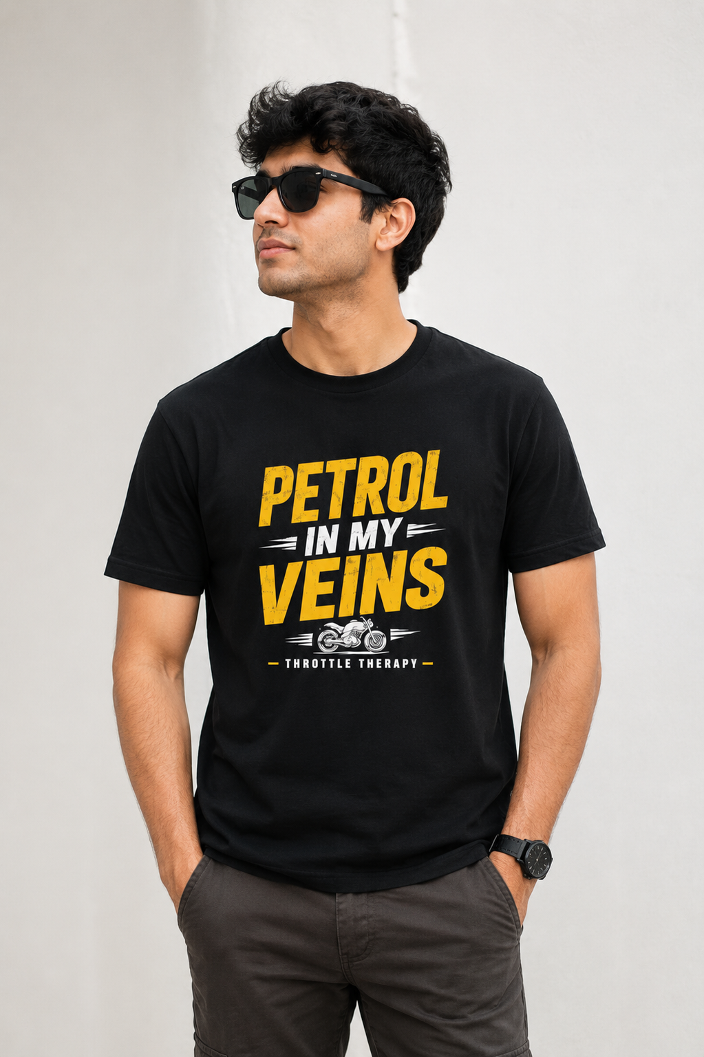 Man wearing a black t-shirt with yellow text 'Petrol in my veins' on a plain background